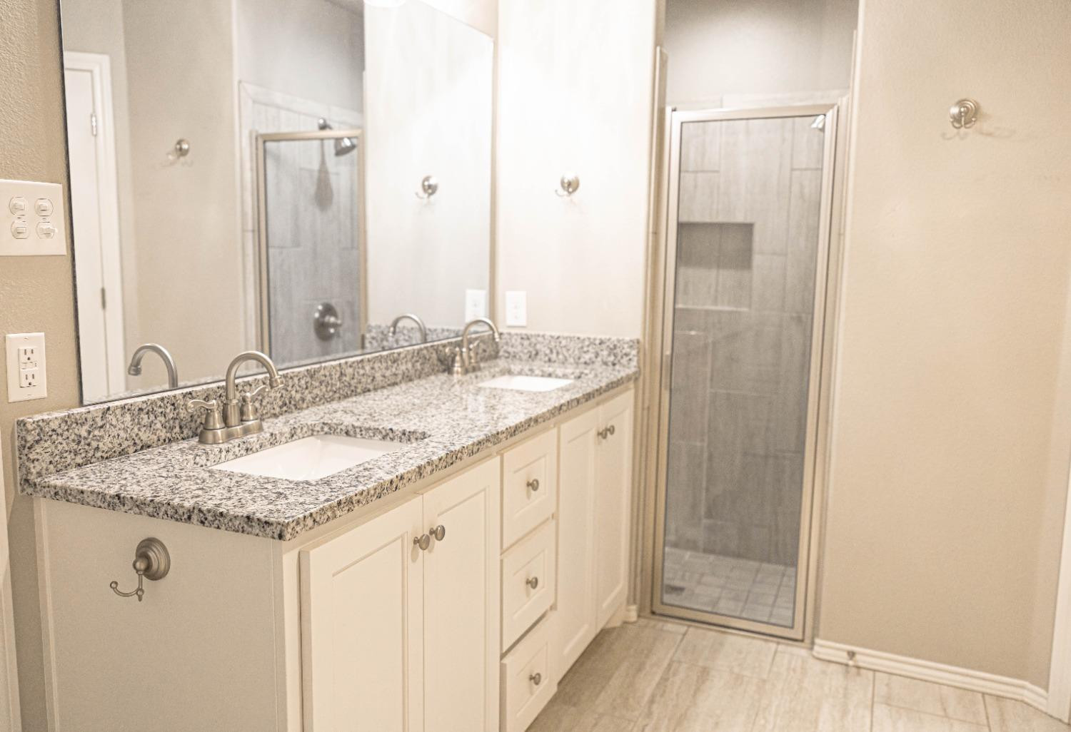 3911 127th Street Lubbock, TX 79423 - Photo 21 of 33 a bathroom with a granite countertop sink and a mirror