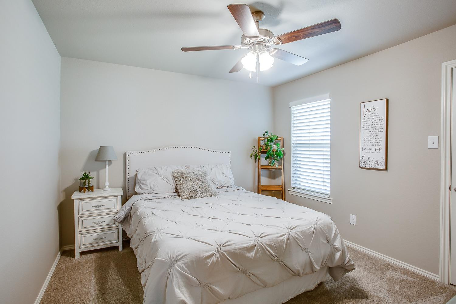 3911 127th Street Lubbock, TX 79423 - Photo 24 of 33 a bedroom with a bed and a chandelier