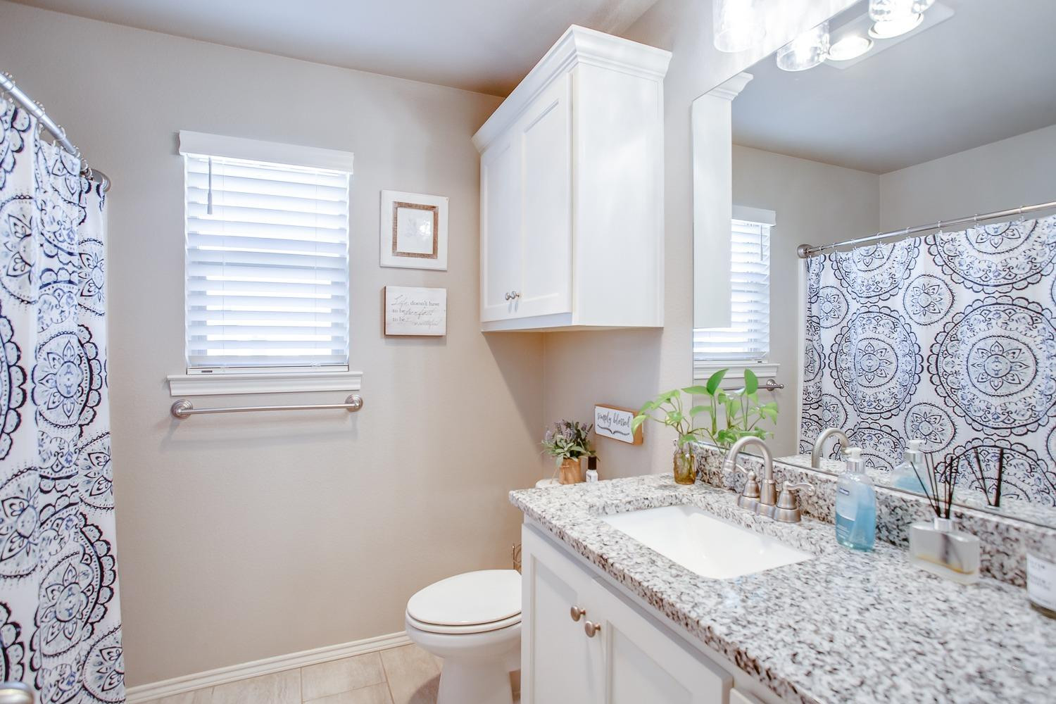 3911 127th Street Lubbock, TX 79423 - Photo 27 of 33 a bathroom with a granite countertop sink and a mirror