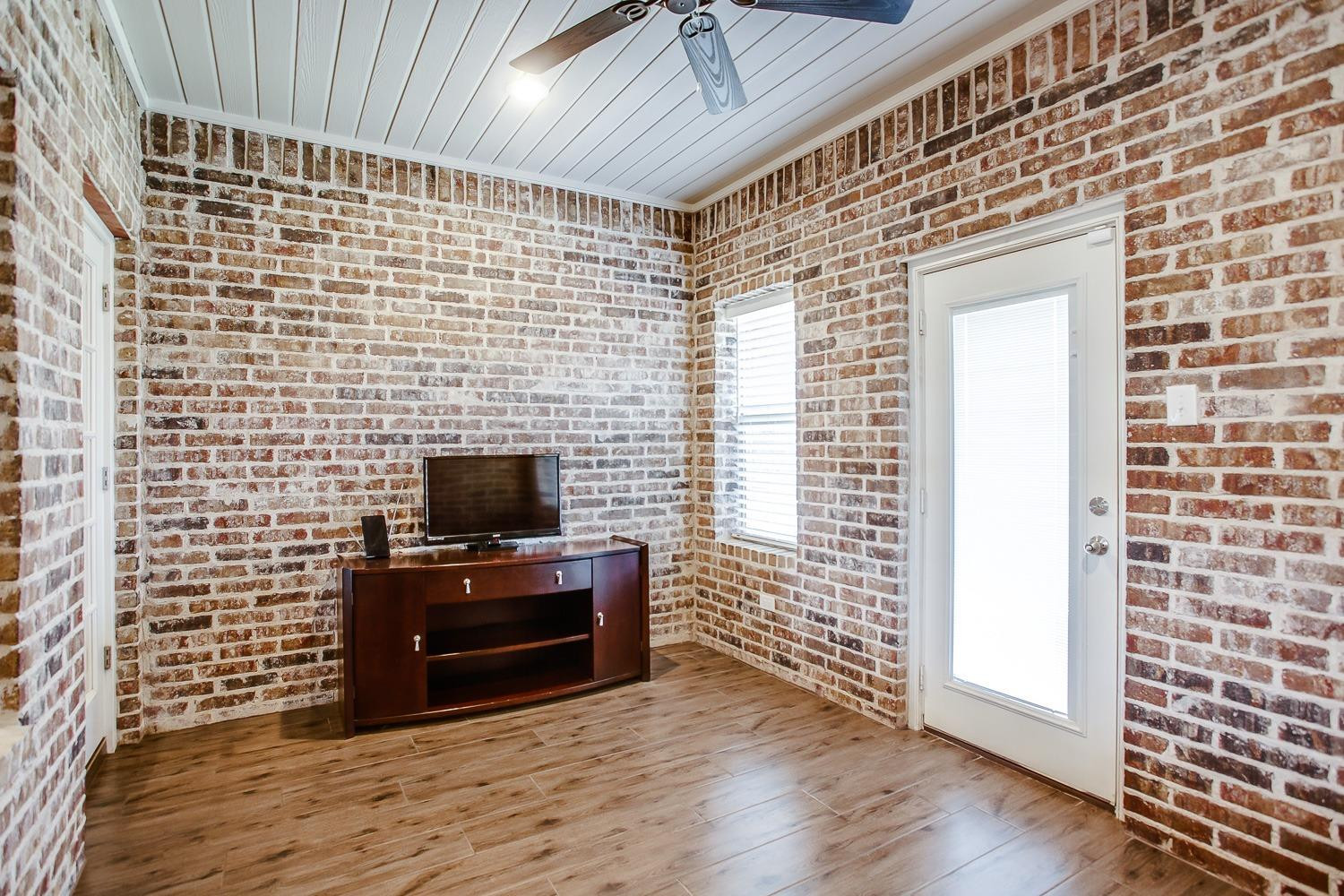 3911 127th Street Lubbock, TX 79423 - Photo 28 of 33 a living room with a wooden floor and a flat screen tv