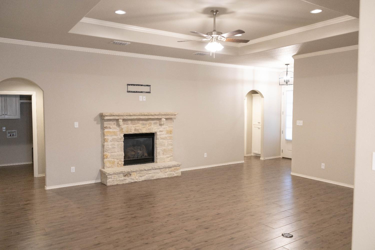 3911 127th Street Lubbock, TX 79423 - Photo 6 of 33 a view of an empty room with wooden floor fireplace and a window