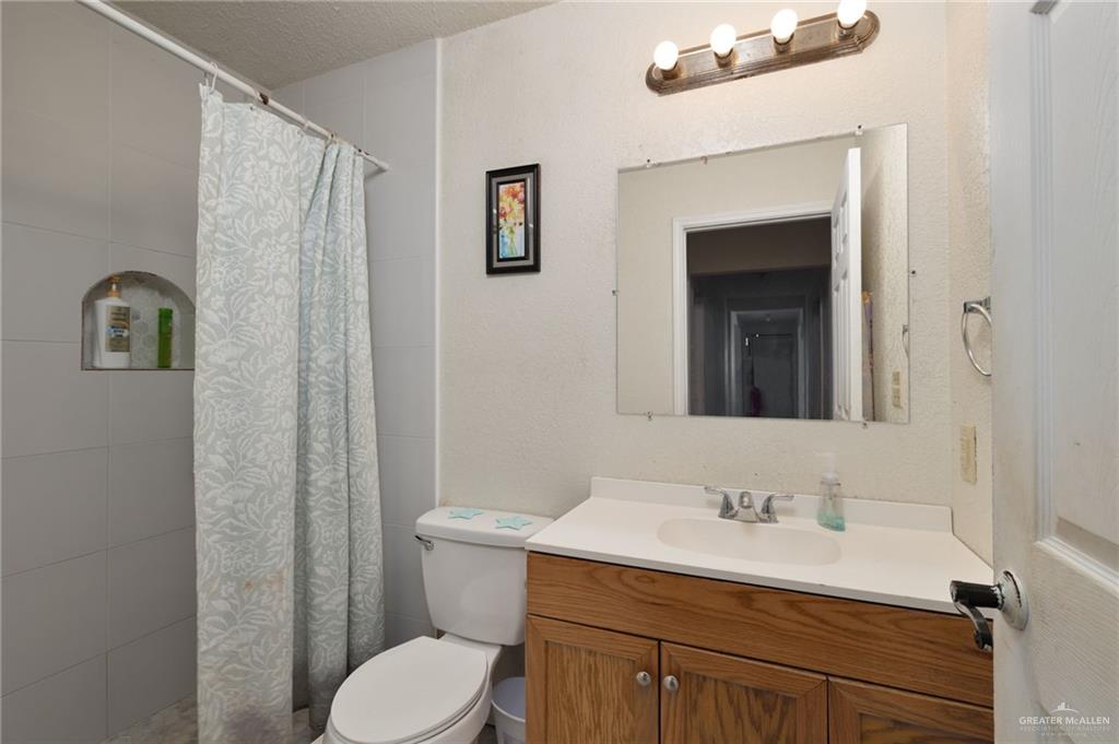 8220 Cardinal Delta Street Mission, TX 78574 - Photo 11 of 18 a bathroom with a granite countertop sink toilet and shower
