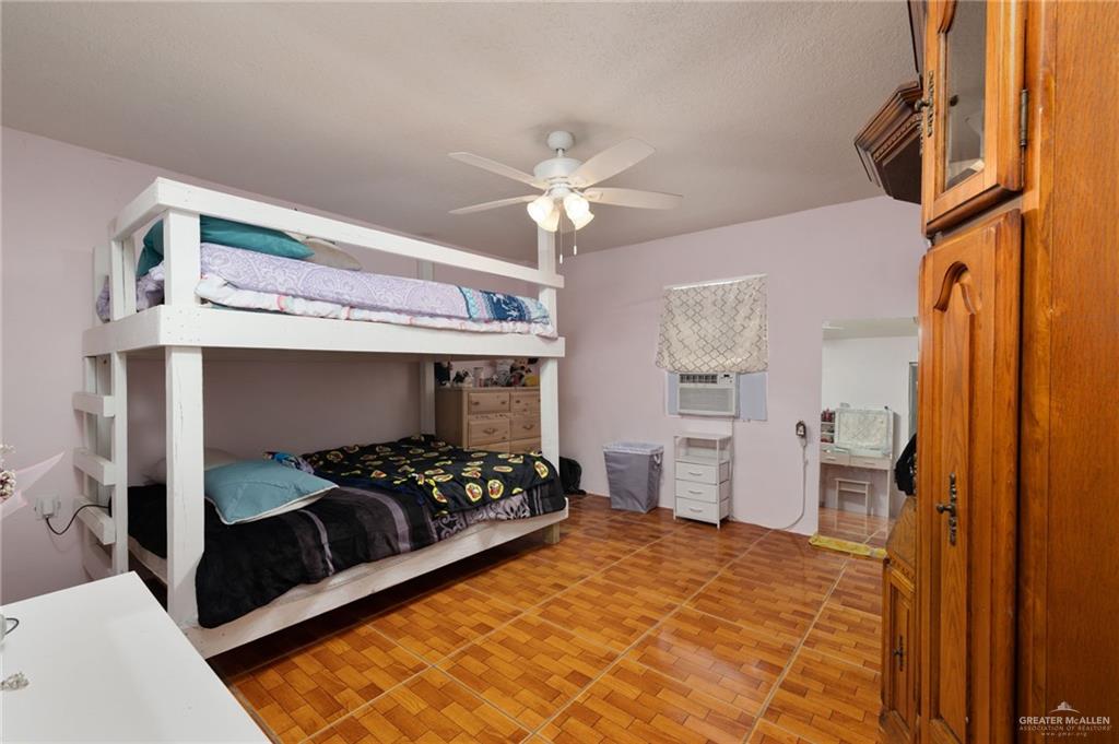 8220 Cardinal Delta Street Mission, TX 78574 - Photo 8 of 18 a bedroom with a bed and a chandelier