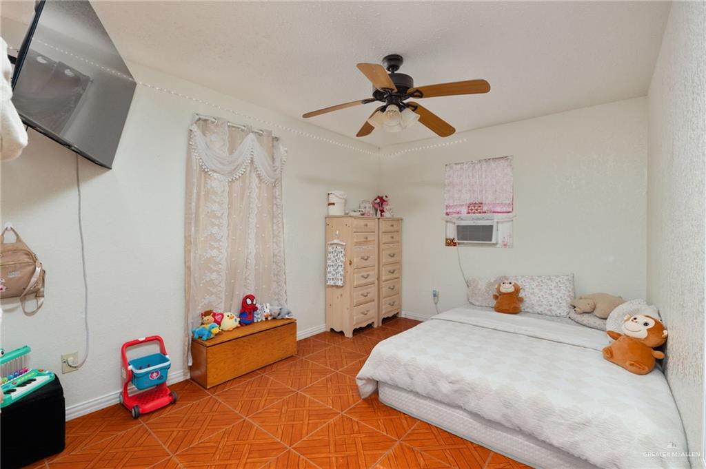 8220 Cardinal Delta Street Mission, TX 78574 - Photo 10 of 18 a bedroom with a bed and a chandelier