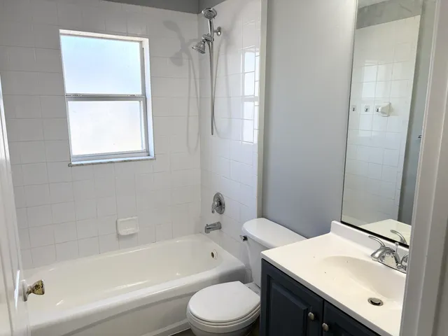 a bathroom with a sink toilet vanity and bathtub