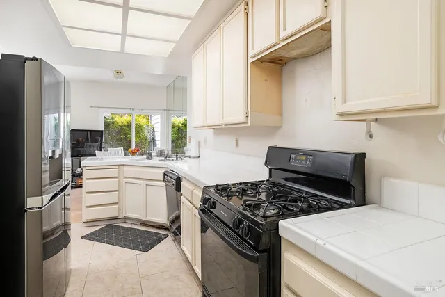 a kitchen with white cabinets and appliances