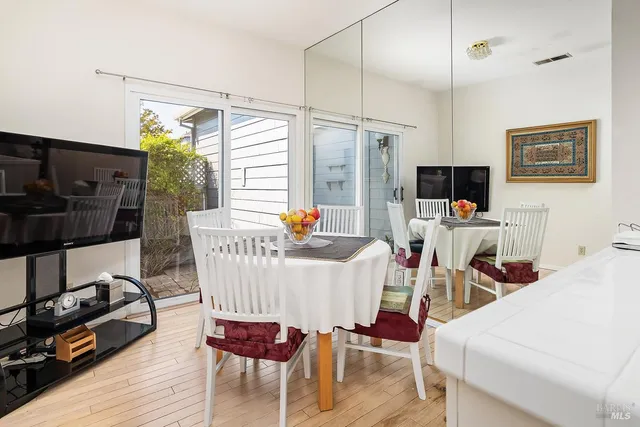 a view of a dining room with furniture a chandelier and wooden floor