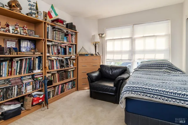 a bedroom with a bed and a book shelf