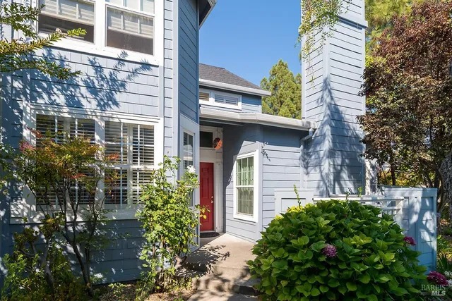 a yellow house with flower garden in front of it