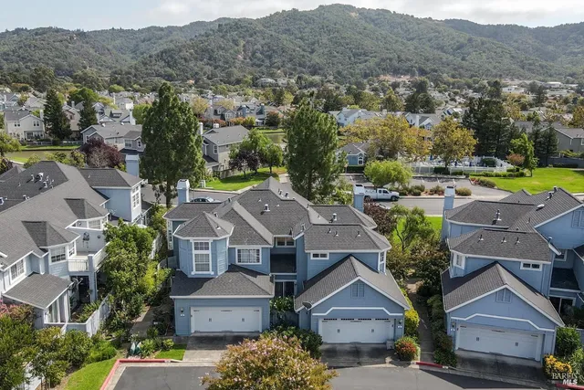 an aerial view of residential houses with outdoor space and parking