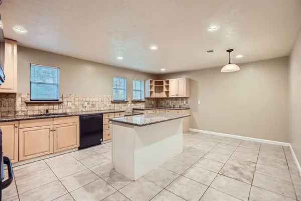 a large white kitchen with a sink and cabinets