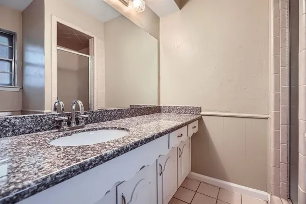 a bathroom with a granite countertop sink and a mirror
