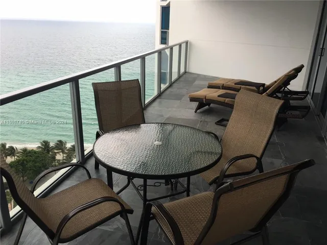a balcony with table and chairs