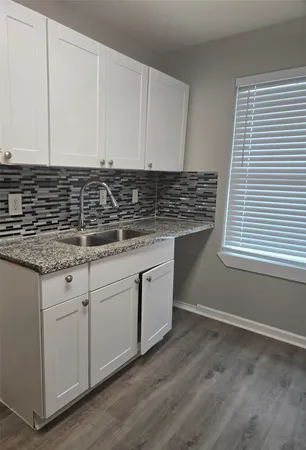 a kitchen with granite countertop white cabinets and white appliances