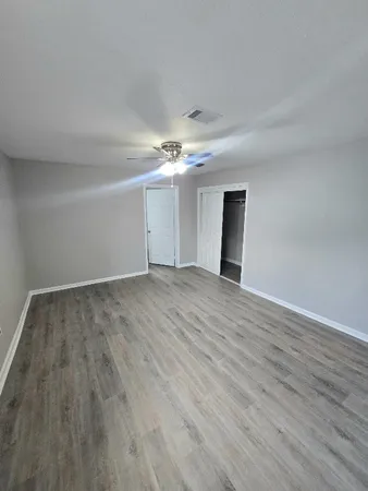 a view of an empty room with wooden floor