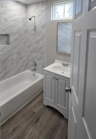 a bathroom with a sink a mirror and a bathtub