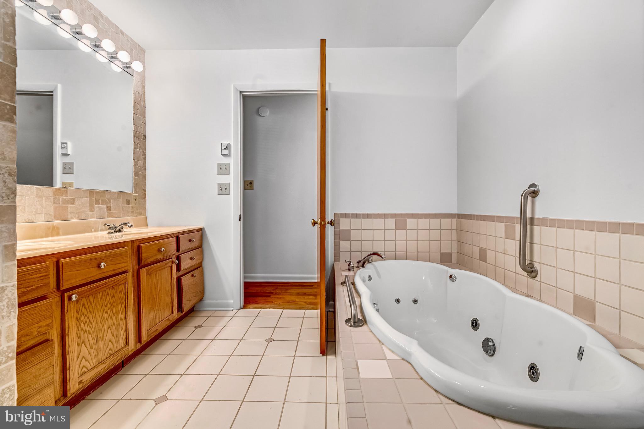 6827 Bellevue Road Royal Oak, MD 21662 - Photo 12 of 32 a spacious bathroom with a tub sink and mirror