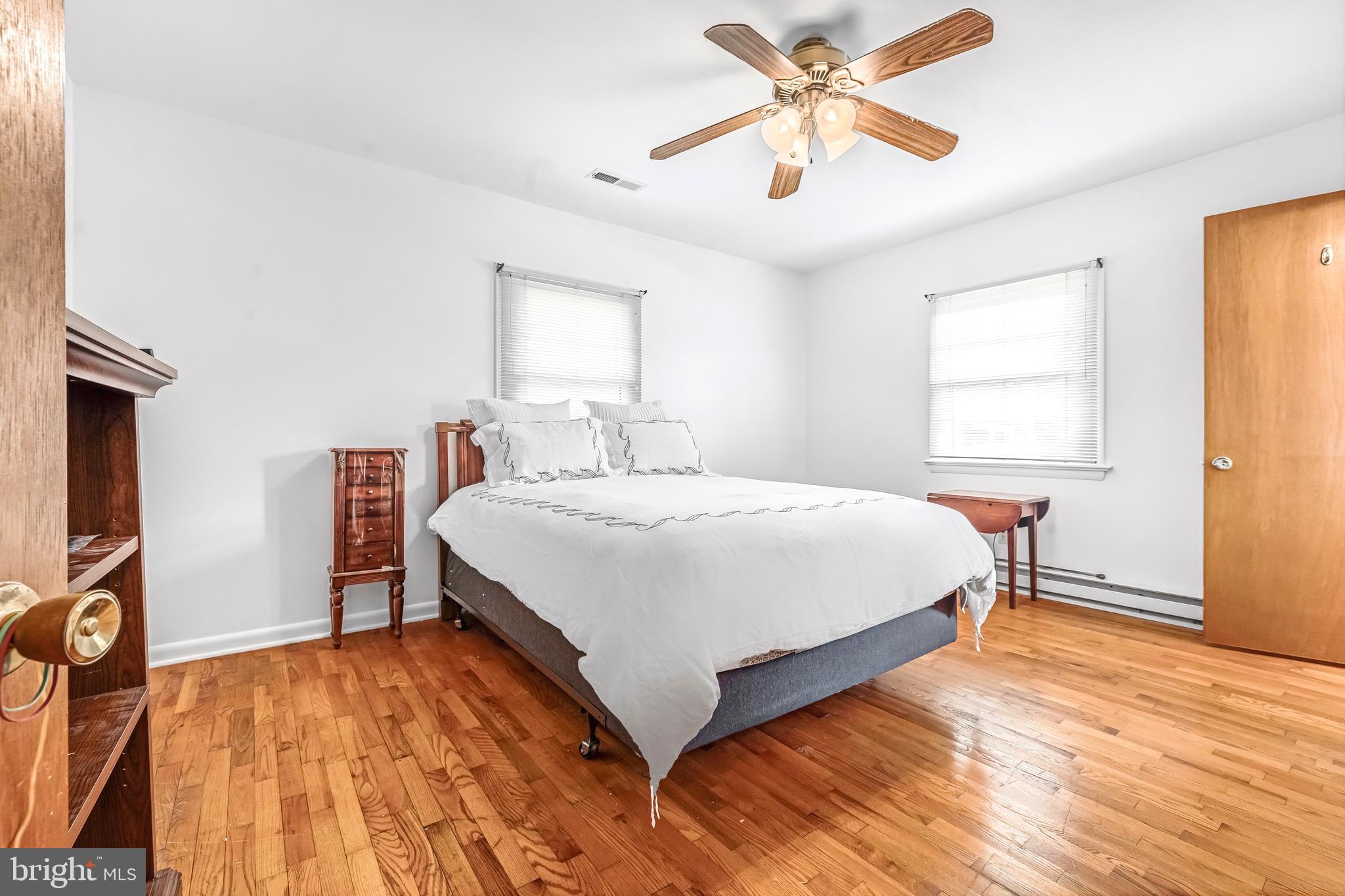 6827 Bellevue Road Royal Oak, MD 21662 - Photo 13 of 32 a bedroom with a bed and a chandelier