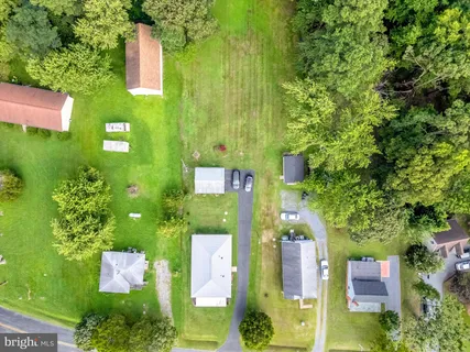 an aerial view of residential house with outdoor space and trees all around