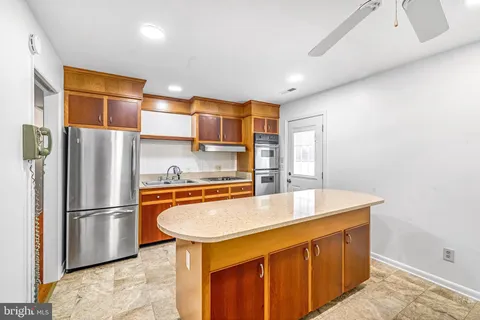 a kitchen with stainless steel appliances granite countertop a refrigerator a sink and a stove