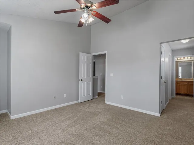 an empty room with closet and a chandelier fan