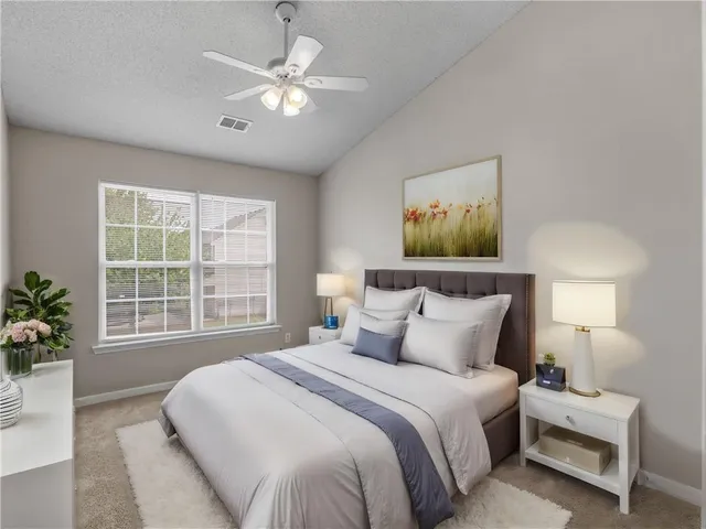 a bedroom with a large bed and a chandelier
