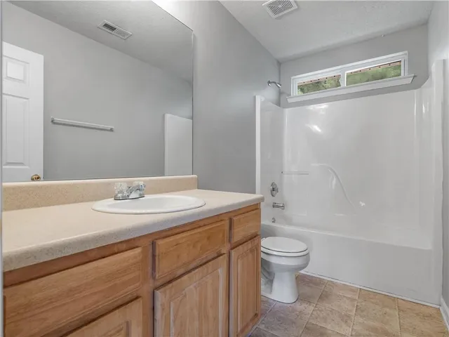 a bathroom with a granite countertop sink a toilet and a large mirror