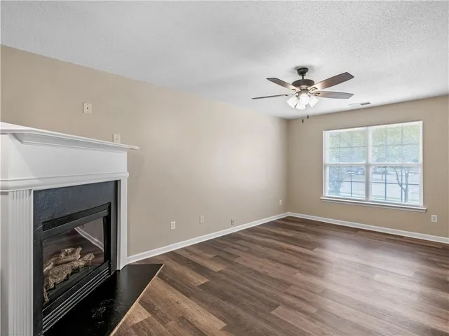 a view of an empty room with windows and a fireplace