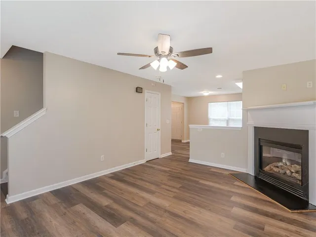 a view of an empty room with a fireplace and a window