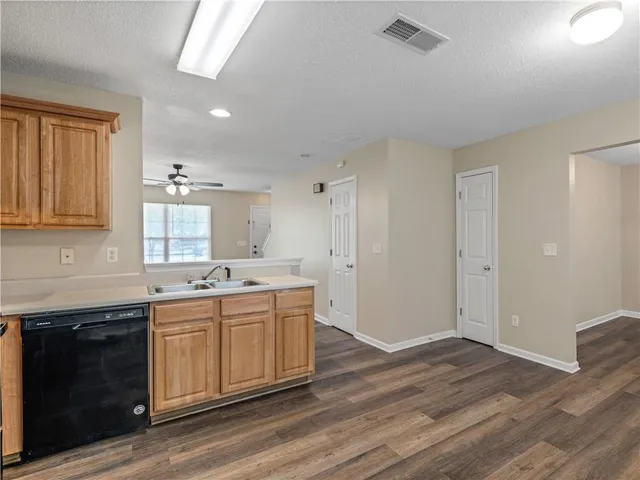 a large kitchen with a sink and dishwasher stove a refrigerator with wooden cabinets