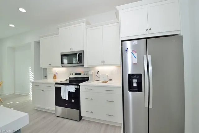 a kitchen with stainless steel appliances a refrigerator sink and cabinets