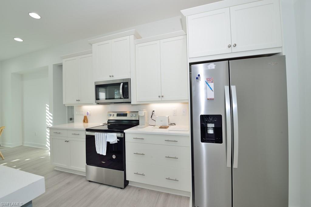 7259 Cayo Coco Lane Naples, FL 34113 - Photo 2 of 20 a kitchen with stainless steel appliances a refrigerator sink and cabinets