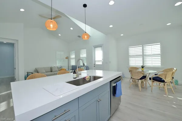 a view of a dining room and livingroom with furniture wooden floor a chandelier