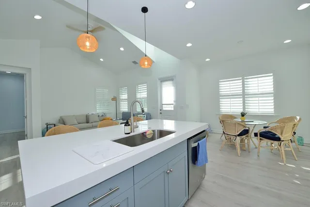 a view of a dining room and livingroom with furniture wooden floor a chandelier