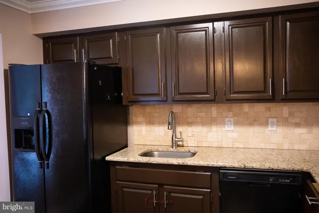 a kitchen with granite countertop a refrigerator and sink