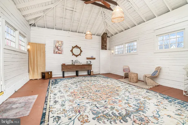 a spacious bedroom with a bed a table and dresser