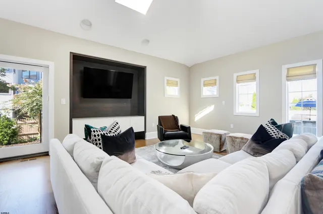 a living room with couches a coffee table and a flat screen tv