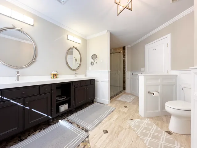 a bathroom with a double vanity sink mirror and toilet