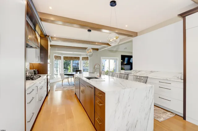 a large kitchen with sink a counter top space and stainless steel appliances