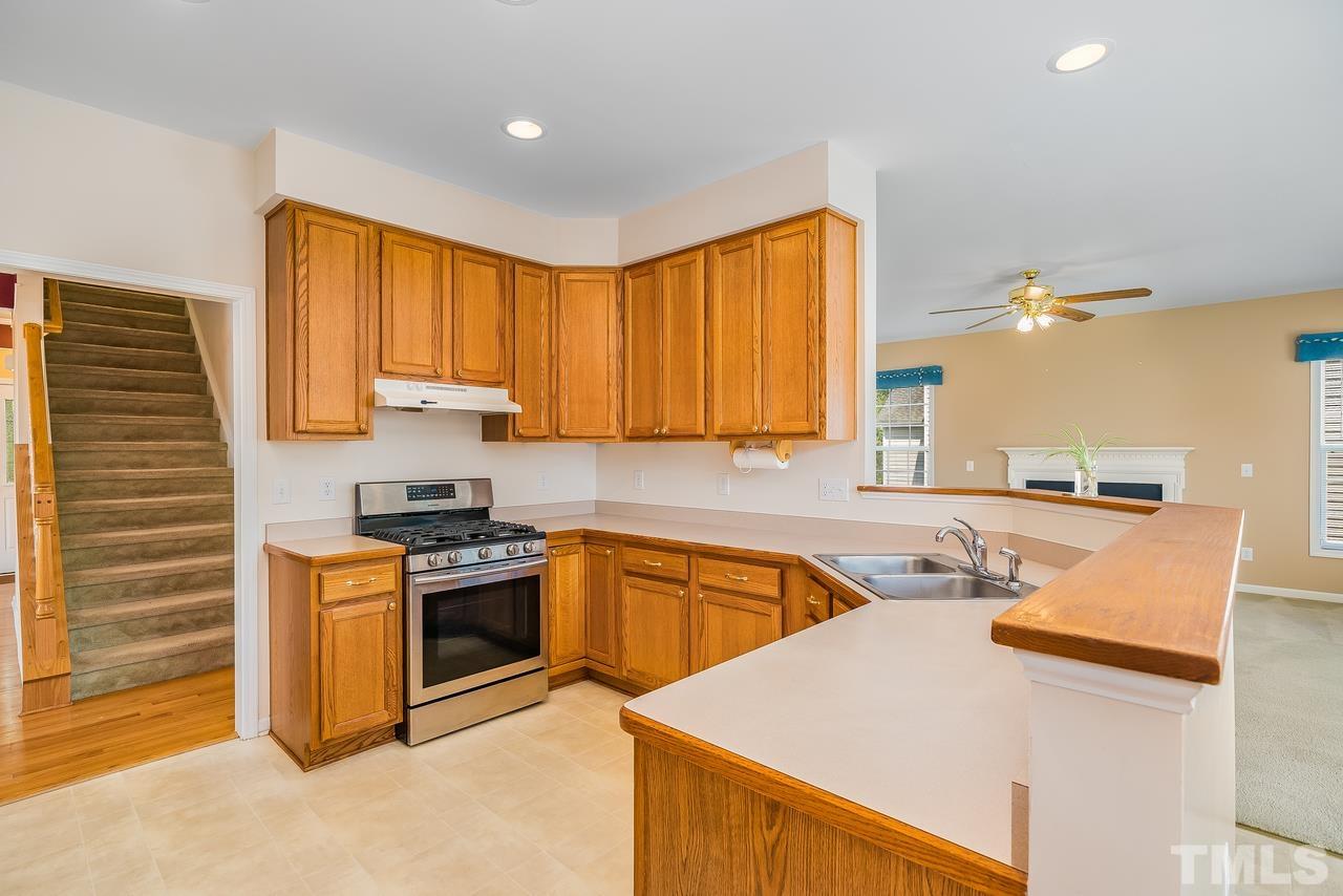 664 Seastone Street Raleigh, NC 27603 - Photo 12 of 25 a kitchen with a stove a sink and a refrigerator