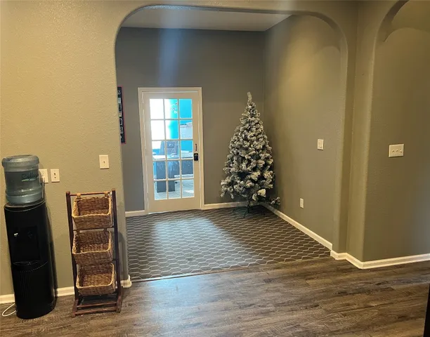 an empty room with wooden floor closet and windows