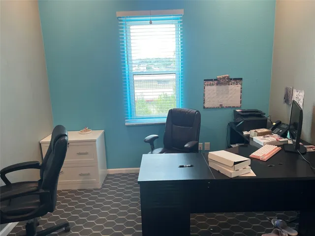 a view of a workspace with furniture and a window