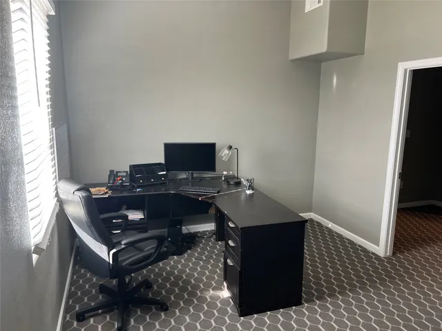 a view of a workspace with furniture and a window