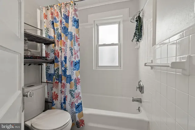 a bathroom with a toilet and a shower curtain