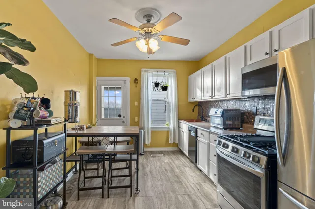 a kitchen with stainless steel appliances a stove a sink dishwasher and a refrigerator with wooden floor