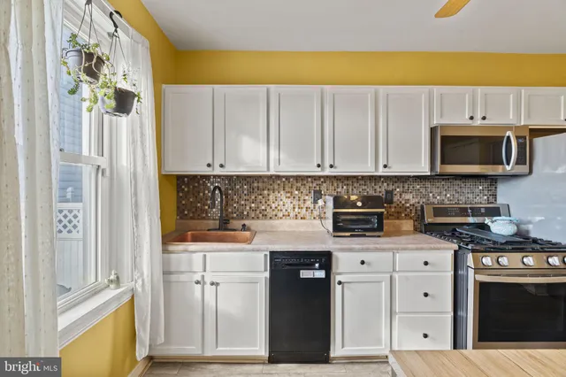 a kitchen with stainless steel appliances granite countertop a stove a microwave and a refrigerator