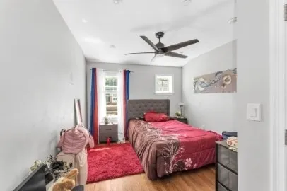 a bedroom with a bed a chandelier and a window