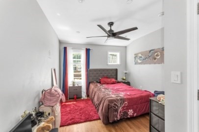 13 Pierce Street, Unit 5 Boston, MA 02136 - Photo 7 of 8 a bedroom with a bed a chandelier and a window