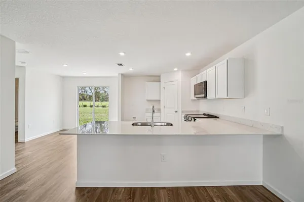 a kitchen with sink a microwave and cabinets