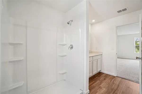 a white house that has a small yard and a large parking space